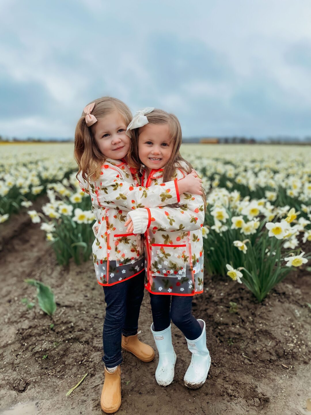 Two little sisters hugging in the tulip fields